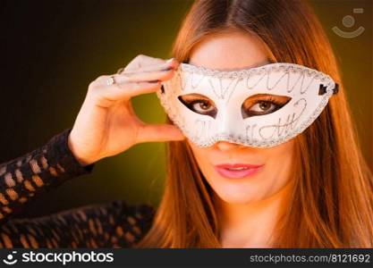 Party time, holidays, people and celebration concept. Woman long hair holds carnival white mask close up. Woman holds carnival mask closeup