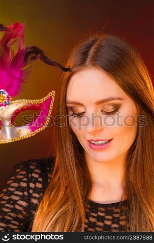 Party time, holidays, people and celebration concept. Woman long hair holds carnival mask close up. Woman holds carnival mask closeup