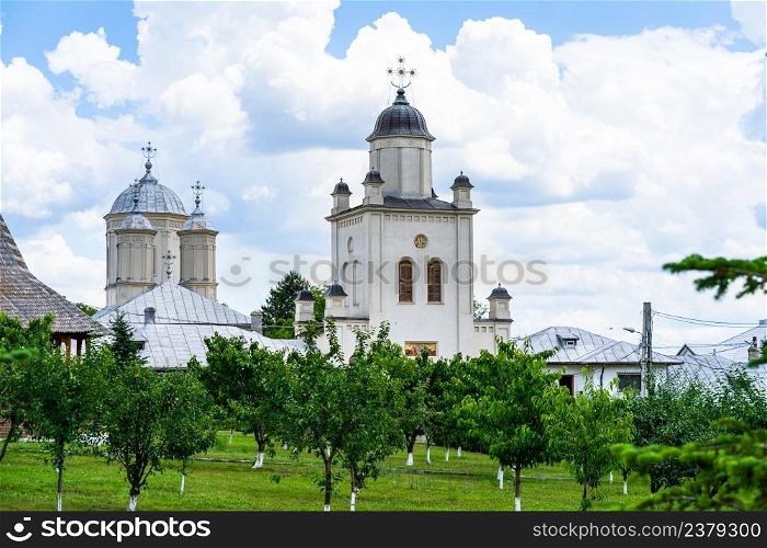 Pasarea monastery, orthodox church architectural details. View of Orthodox church and green churchyard.