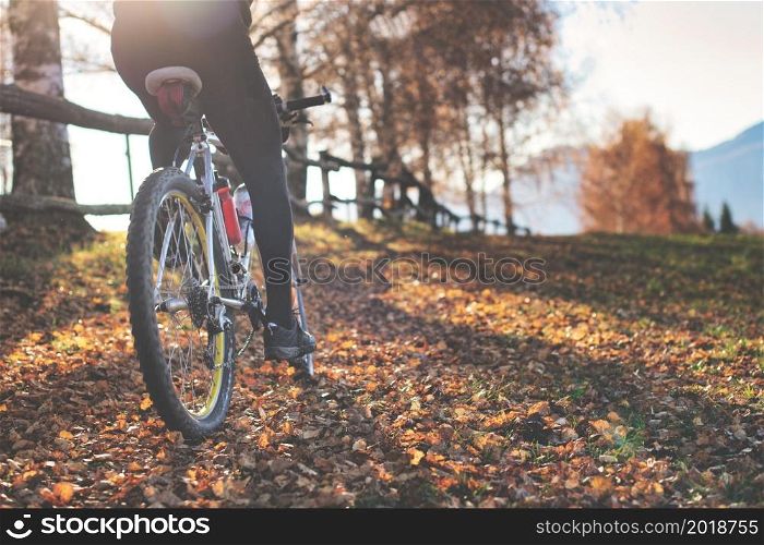 Passage of a mountain bike on leafy paths in the hills in autumn