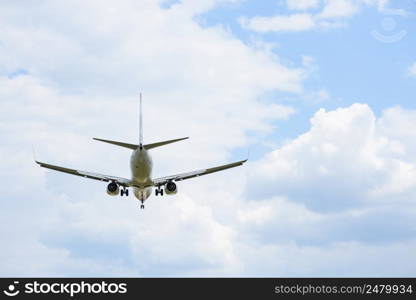 Passenger airplane in the clouds rear side view