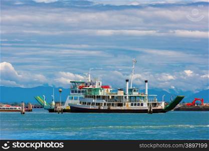 Passenger and cargo ships in the Venetian lagoon on the background of the sea, sky and mountains summer sunny day, Venice, Italy