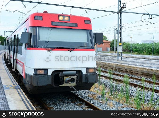 Passenger electric train stopped at platform in Blanes, Spain.