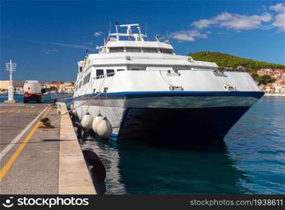 Passenger ferry near the pier in the seaport. Split Croatia.. Passenger sea ferry with a fuel tanker on the pier.