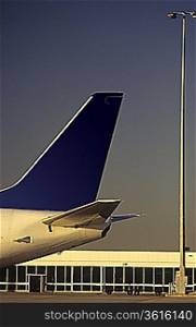 Passenger jet tailplane against airport terminal