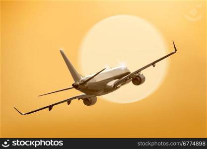 passenger plane fly down over take-off runway from airport at sunset