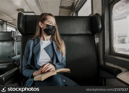 passenger train wearing medical mask looking out window