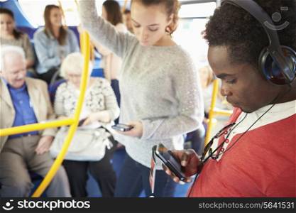 Passengers Using Mobile Devices On Bus Journey