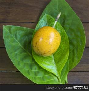 Passion fruits and Green Leaf on Wooden Background