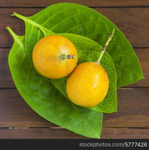 Passion fruits and Green Leaf on Wooden Background