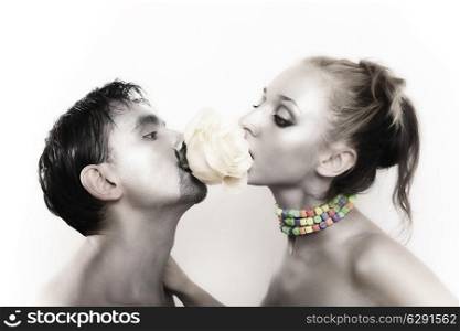 passionate couple with silver makeup kissing flower white roses