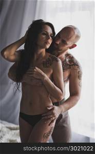Passionate embrace at the naked torso of the bodies of men and women.. A man embraces a girl naked to the waist covering the breast 239.
