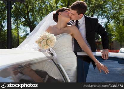 Passionate married couple kissing while standing in limo