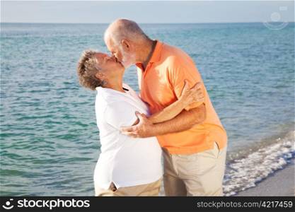 Passionate senior couple kissing on the beach.