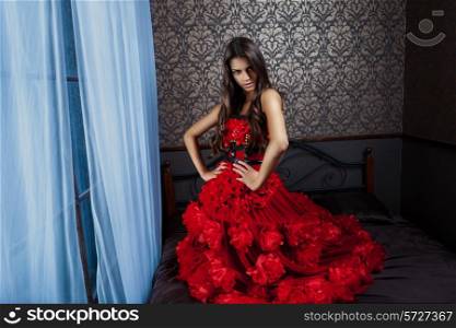 Passionate woman in red dressin in interior
