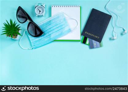 Passport and medical mask on a blue background. Safe travel concept during the coronavirus pandemic. Flatlay, copy space.. Passport and medical mask on a blue background. Safe travel concept during the coronavirus pandemic.