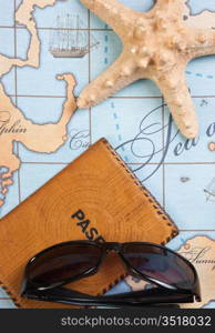 passport and sunglasses on a map