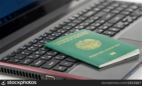 Passport of Uzbekistan on the laptop keyboard. Online registration. Passport of Uzbekistan on the keyboard