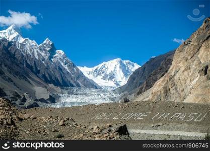 Passu glacier with text 'Welcome to PASU', surrounded by mountains in Karakoram range. Passu, Gojal Hunza. Gilgit Baltistan, Pakistan.