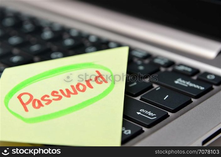 Password written on yellow note on black keyboard