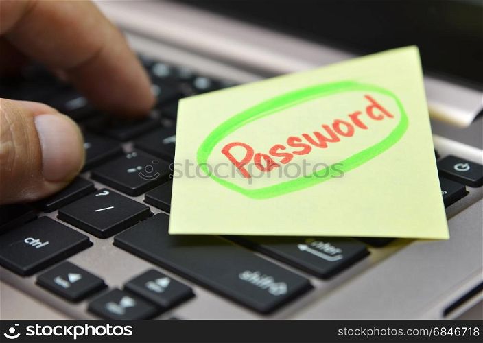 Password written on yellow note on black keyboard. Password written on yellow note