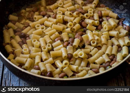 pasta and beans in a pan with celery and onion