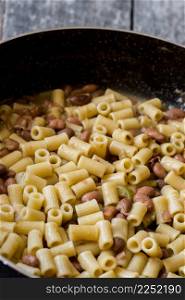 pasta and beans in a pan with celery and onion