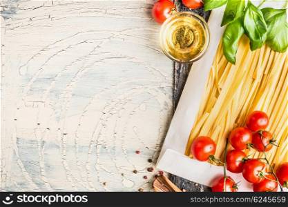 Pasta and cooking ingredients: tomatoes, basil and oil on light background, top view, place for text. Italian food concept
