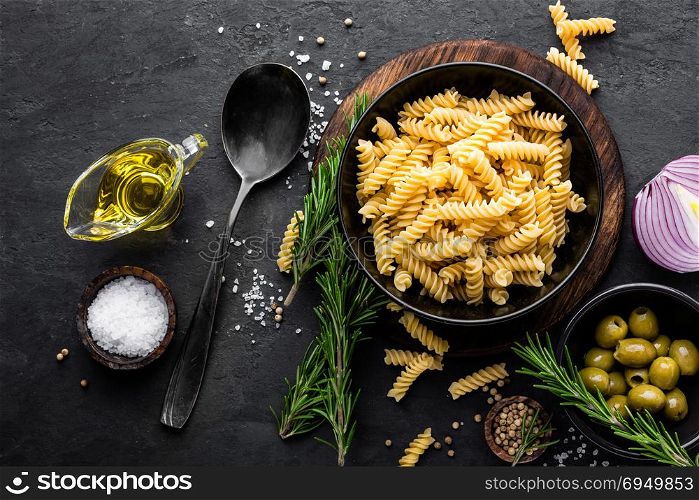 Pasta and ingredients for cooking on black background, top view. Italian food