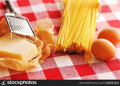 Pasta and ingredients over red cloth