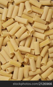 pasta concept many of large, tube-shaped rigatoni pasta with ridged edges being grouped.