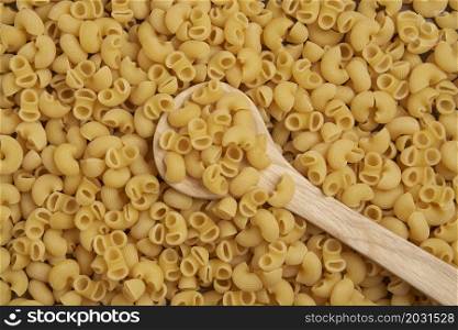 pasta concept the large amounts of dry yellow tubular-shaped short-cut macaroni pasta sorted together.