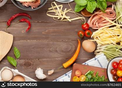 Pasta cooking ingredients and utensils on wooden table. Top view with copy space
