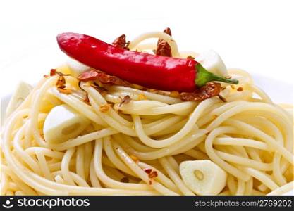 pasta garlic olive oil and red chili pepper closeup on a white dish