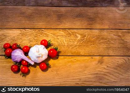 Pasta ingredients on wooden table. Cherry tomato, onion, garlic