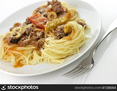 pasta nests with meat and vegetables in a white plate