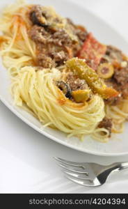 pasta nests with meat and vegetables in a white plate