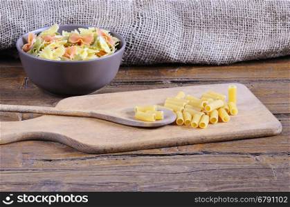 Pasta on a cutting board in a wooden table.