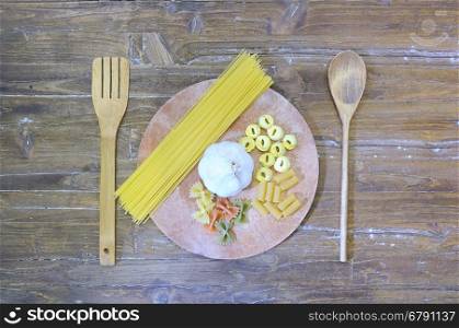 Pasta on a cutting board in a wooden table.