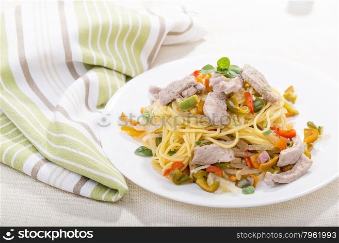 Pasta or spaghetti with chicken and herbs on a white plate