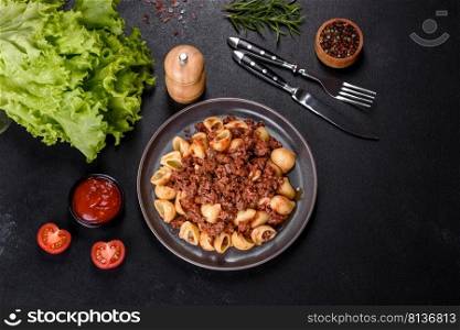 Pasta pappardelle with beef ragout sauce in black bowl. Dark background. Italian pasta tagliatelle with traditional homemade meat sauce