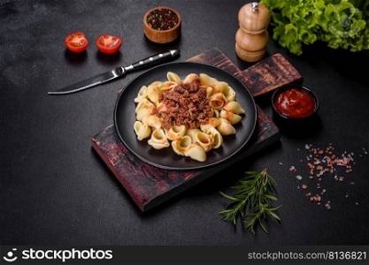 Pasta pappardelle with beef ragout sauce in black bowl. Dark background. Italian pasta tagliatelle with traditional homemade meat sauce