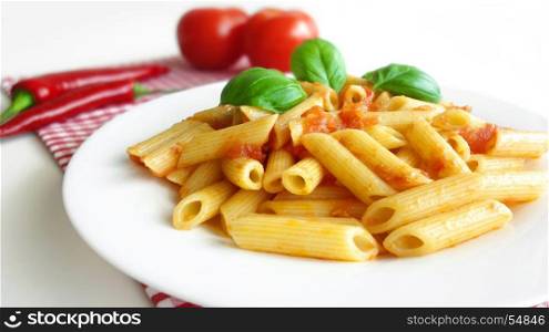 Pasta penne with tomato sauce and basil mediterranean food background.
