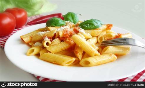 Pasta penne with tomato sauce mediterranean food background.