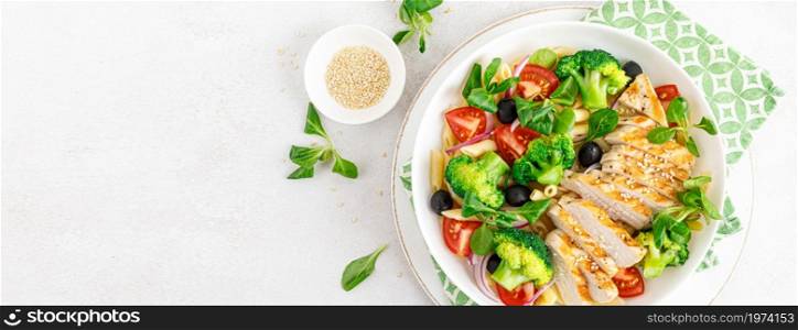 Pasta salad bowl with broccoli, tomato, onion, olives, corn salad and grilled chicken breast for lunch. Healthy dietary food. Top view. Banner.