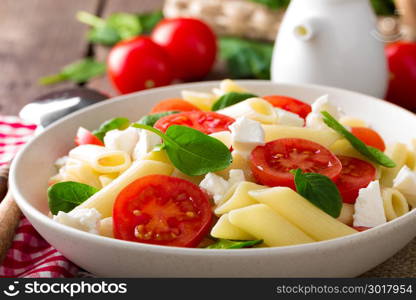 Pasta salad with fresh red cherry tomato and feta cheese. Italian cuisine