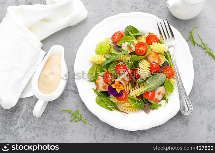 Pasta salad with grilled chicken meat, vegetables and cheese
