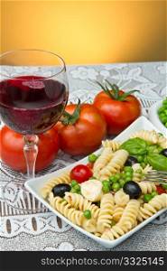 Pasta salad with mozzarella with a glass of red wine