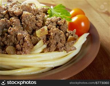 pasta with beef on wooden table