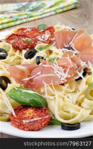 Pasta with gammon, olives, sun-dried tomatoes and parmesan